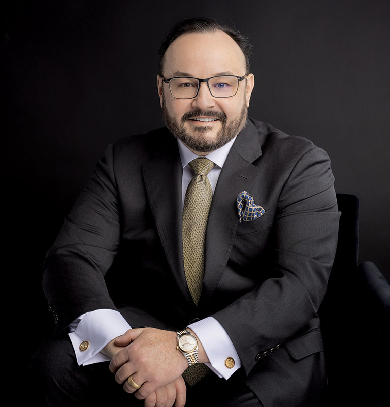Dr. Aldo Guerra wearing a suit