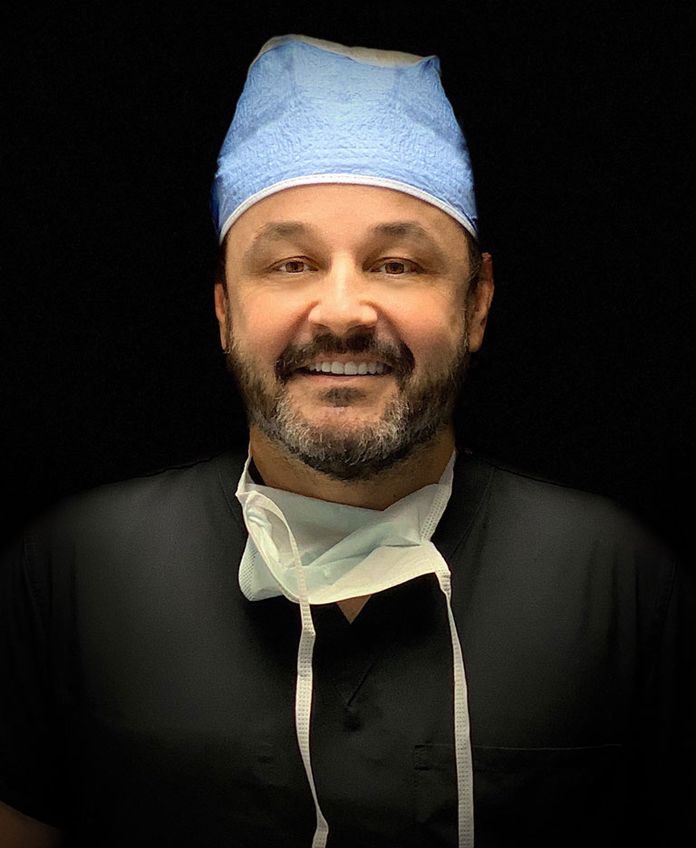 Dr. Aldo Guerra in dark scrubs