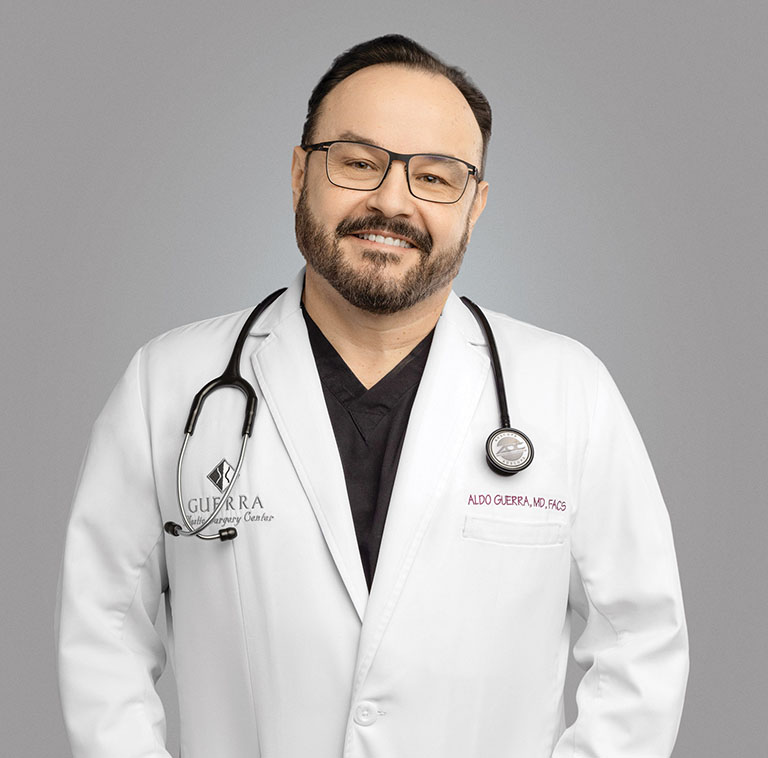 Dr. Aldo Guerra wearing a white lab coat with stethoscope